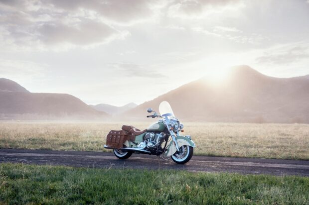 Classic Indian vintage motorcycle parked on a rural road with mountains in the background