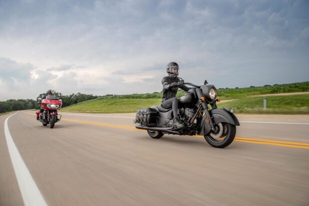 Rider wearing helmet on Indian vintage motorcycle riding on open road