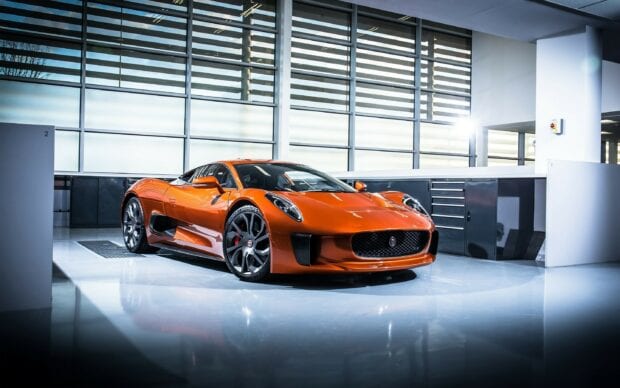 Orange Jaguar Cars sports car parked in a modern garage with bright windows