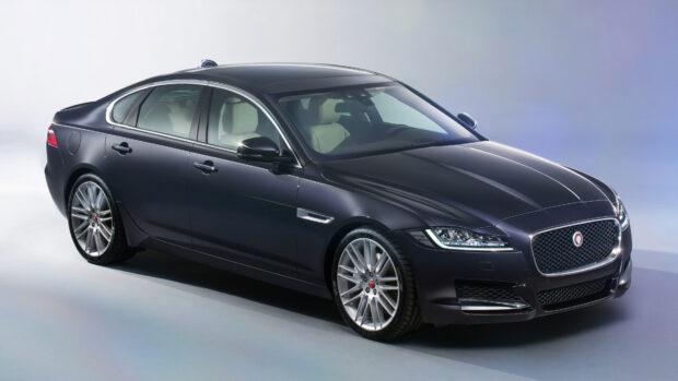 A sleek black Jaguar car showcased from the side in a studio setting
