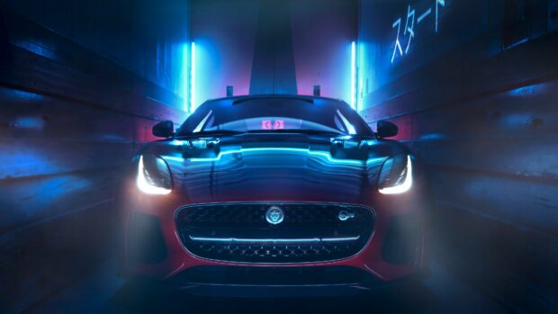 Front view of sleek Jaguar car in neon lit tunnel showcasing Jaguar Cars design
