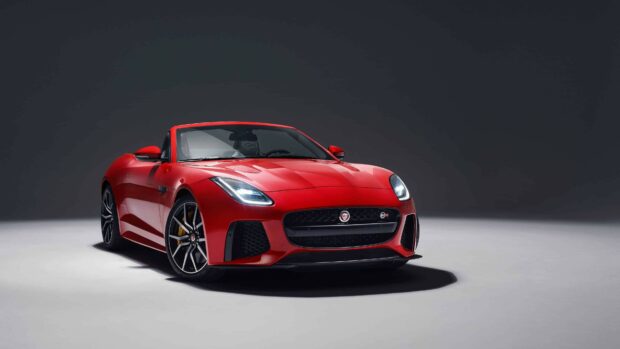 Red Jaguar car in a studio setting showcasing a sleek and sporty design