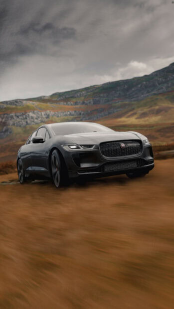 Black Jaguar Cars driving on a rugged landscape with hills in the background