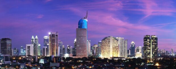 Jakarta city skyline with modern skyscrapers under a purple evening sky