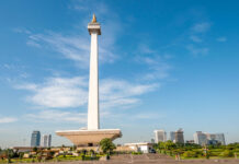 The National Monument in Jakarta with clear blue sky and city skyline in the background