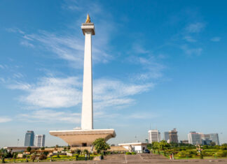 The National Monument in Jakarta with clear blue sky and city skyline in the background
