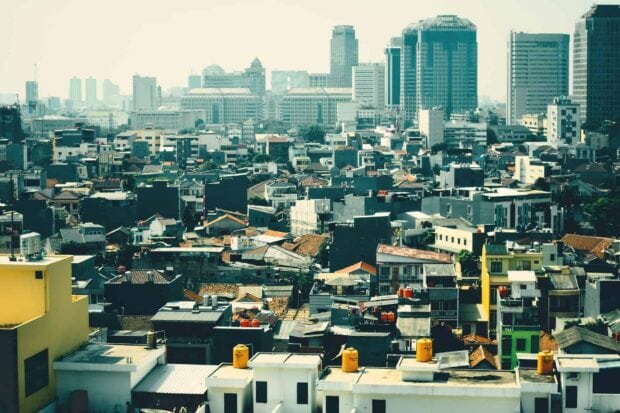 A dense urban Jakarta cityscape showing buildings and houses in the city center