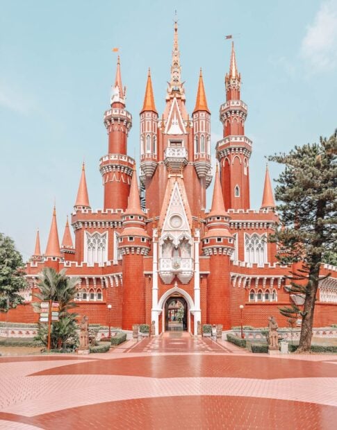 Historic castle architecture in Jakarta with red brick towers and blue sky