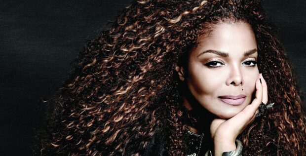 Close up of Janet Jackson with curly hair and hand supporting her face