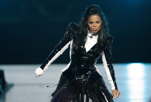 Janet Jackson wearing a black and white studded outfit performing on stage
