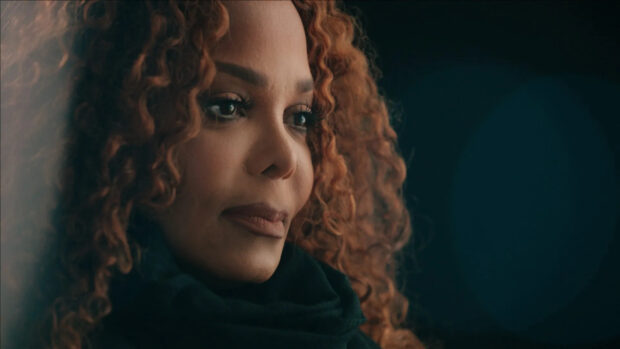 Janet Jackson with curly hair and thoughtful expression in close up portrait