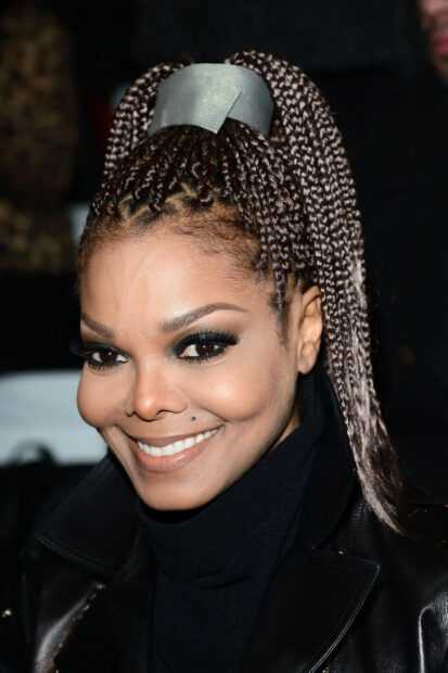 Close up of Janet Jackson with braided hair and a bright smile