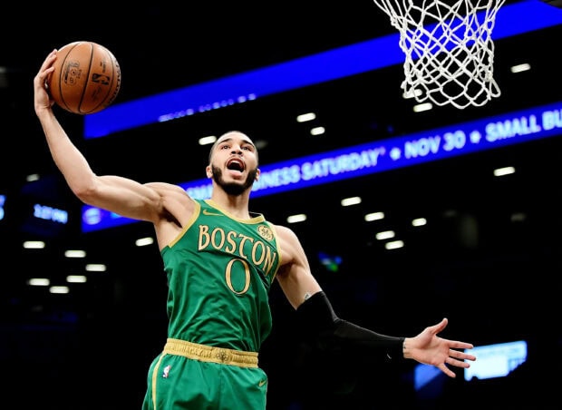 Jayson Tatum making a jump shot during a basketball game in a Boston jersey