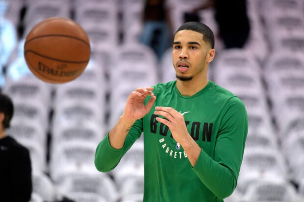 Jayson Tatum practicing basketball in green Boston shirt during warm up session