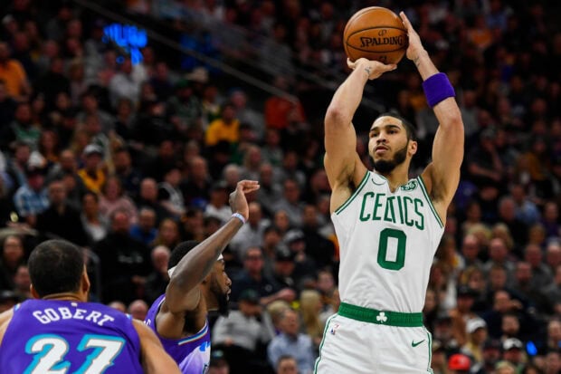 Jayson Tatum preparing to shoot a basketball in a Celtics jersey during a game