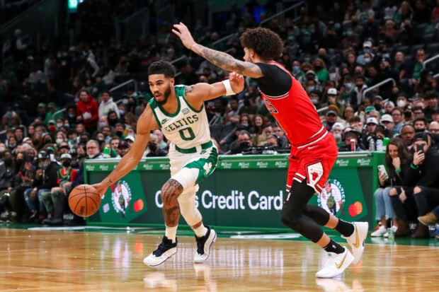 Jayson Tatum dribbling the basketball during a Celtics game against the Bulls defender