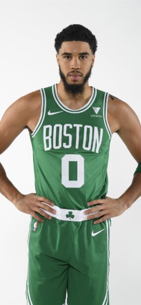 Jayson Tatum in a green Boston basketball uniform standing with hands on hips