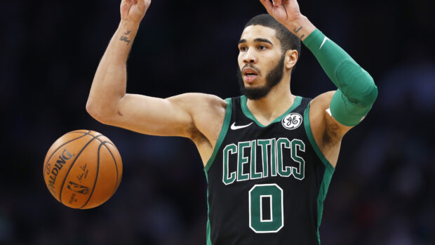 Jayson Tatum wearing a Celtics jersey preparing to pass the basketball during a game
