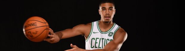 Jayson Tatum in a Celtics jersey passing a basketball against a black background
