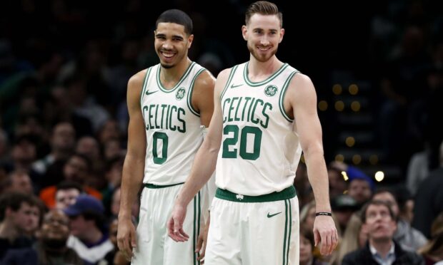 Jayson Tatum standing on the basketball court with a teammate during a game