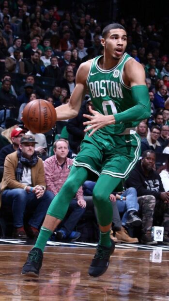 Jayson Tatum playing basketball in a Boston Celtics uniform during an intense game