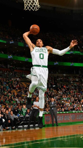 Jayson Tatum jumping high to dunk the basketball during a game