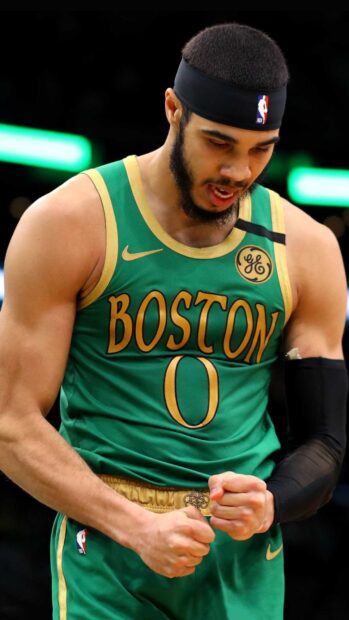 Jayson Tatum in Boston Celtics jersey showing determination during a basketball game