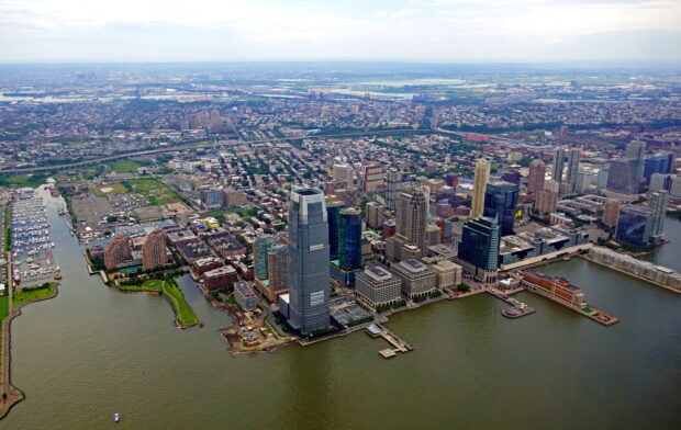 Aerial view of Jersey City skyline with tall buildings and waterfront in the background