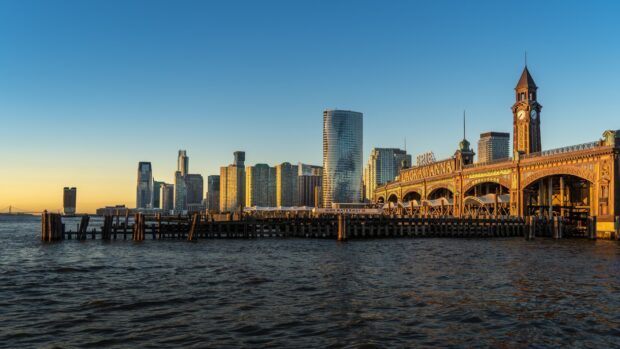 Historic Lackawanna Terminal and Jersey City skyline at sunset with water view