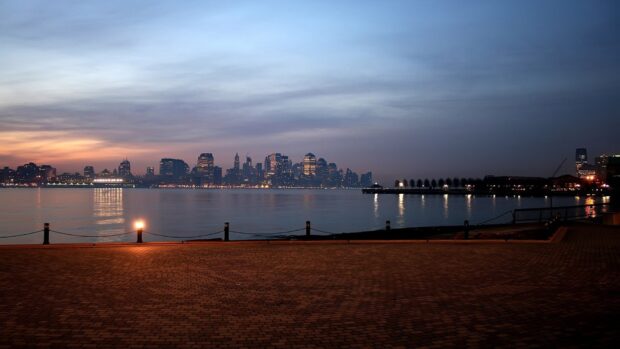 Jersey City skyline at dusk with calm water and illuminated buildings in HD quality
