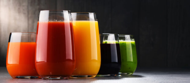 Various fresh juice glasses with vibrant colors arranged on a table