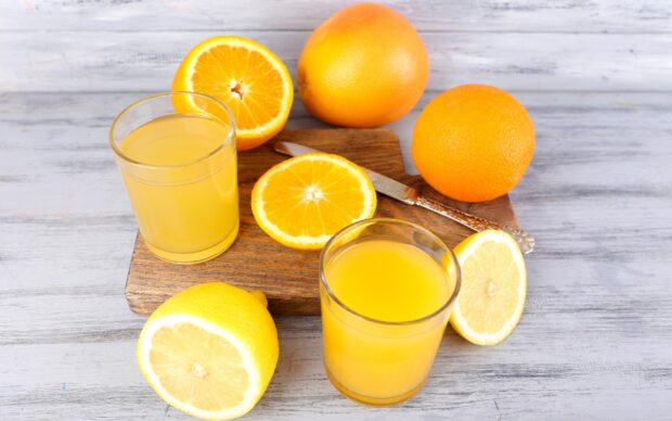 Fresh citrus juice with orange and lemon fruit on wooden board
