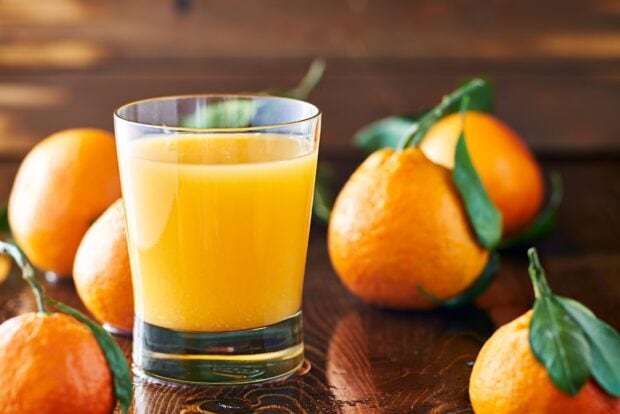 Fresh citrus juice with tangerines on a wooden table