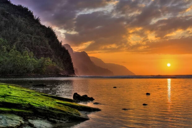 Kauai sea cliffs with green mossy rocks at sunset