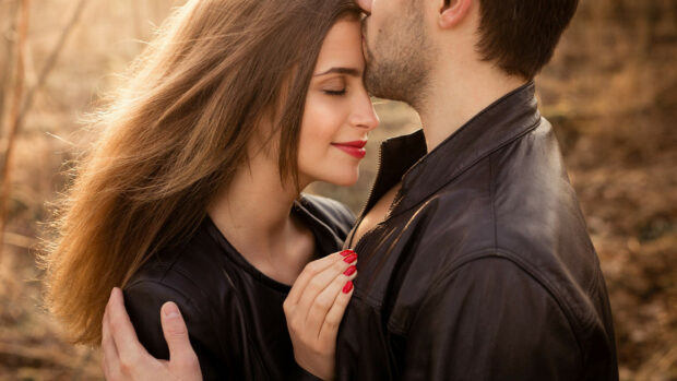 A loving couple sharing a tender kiss moment in the outdoors with natural light