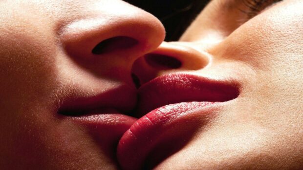 Close up of a kiss showing lips and noses in intimate moment