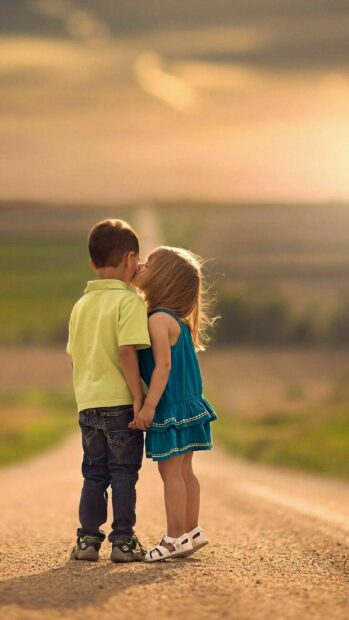 Little girl giving a sweet kiss to boy on a country road kiss