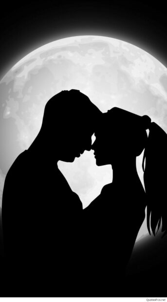 Silhouette of a couple sharing a kiss under the full moon in a romantic scene
