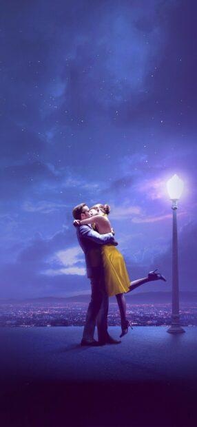 A couple sharing a romantic kiss under a streetlamp with a starry sky background