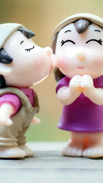 Cute couple figurines sharing a kiss showing love and affection