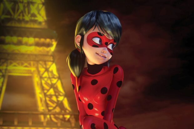 A ladybug superhero character smiling with the Eiffel Tower illuminated in the background