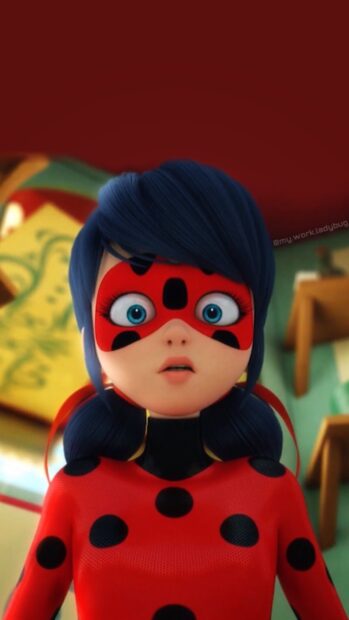 A surprised girl wearing a red suit with black dots and a ladybug mask looking ahead