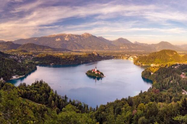 Lake Bled surrounded by mountains and forests with a small island in the middle of the lake