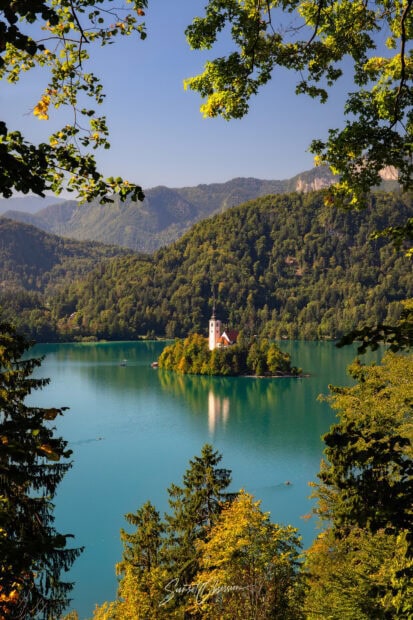 A serene view of Lake Bled with a small island and church surrounded by lush green hills