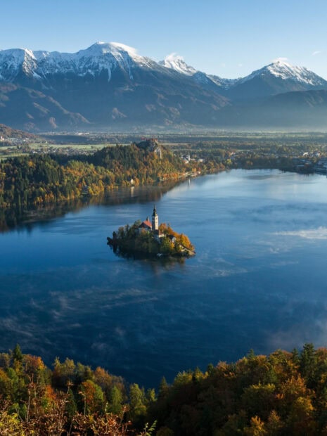 Autumn landscape with Lake Bled surrounded by mountains and forest in HD quality