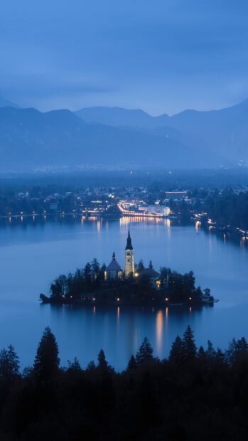 Mystical view of Lake Bled island with church and mountains in the background at twilight