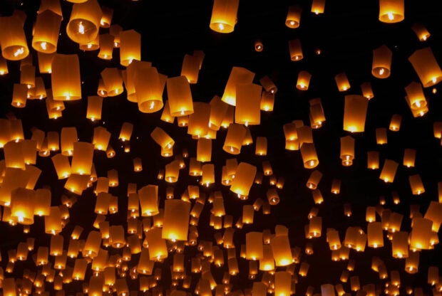 Glowing lanterns floating into the night sky during a vibrant lanterns festival