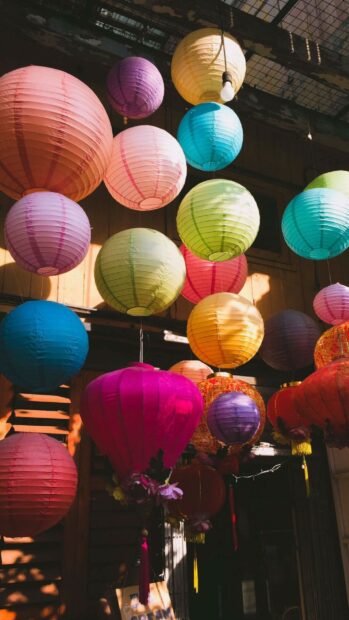 Colorful lanterns hanging under warm sunlight in an outdoor setting