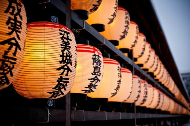 Traditional lanterns with Japanese characters hanging in a row at dusk