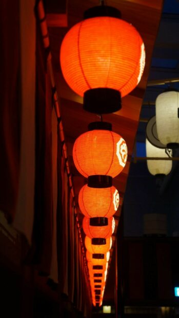 A row of glowing red lanterns hanging in the night sky